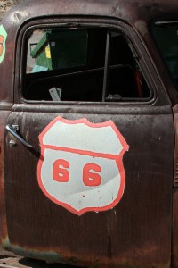 Old rusty car with the sign 66 painted on it